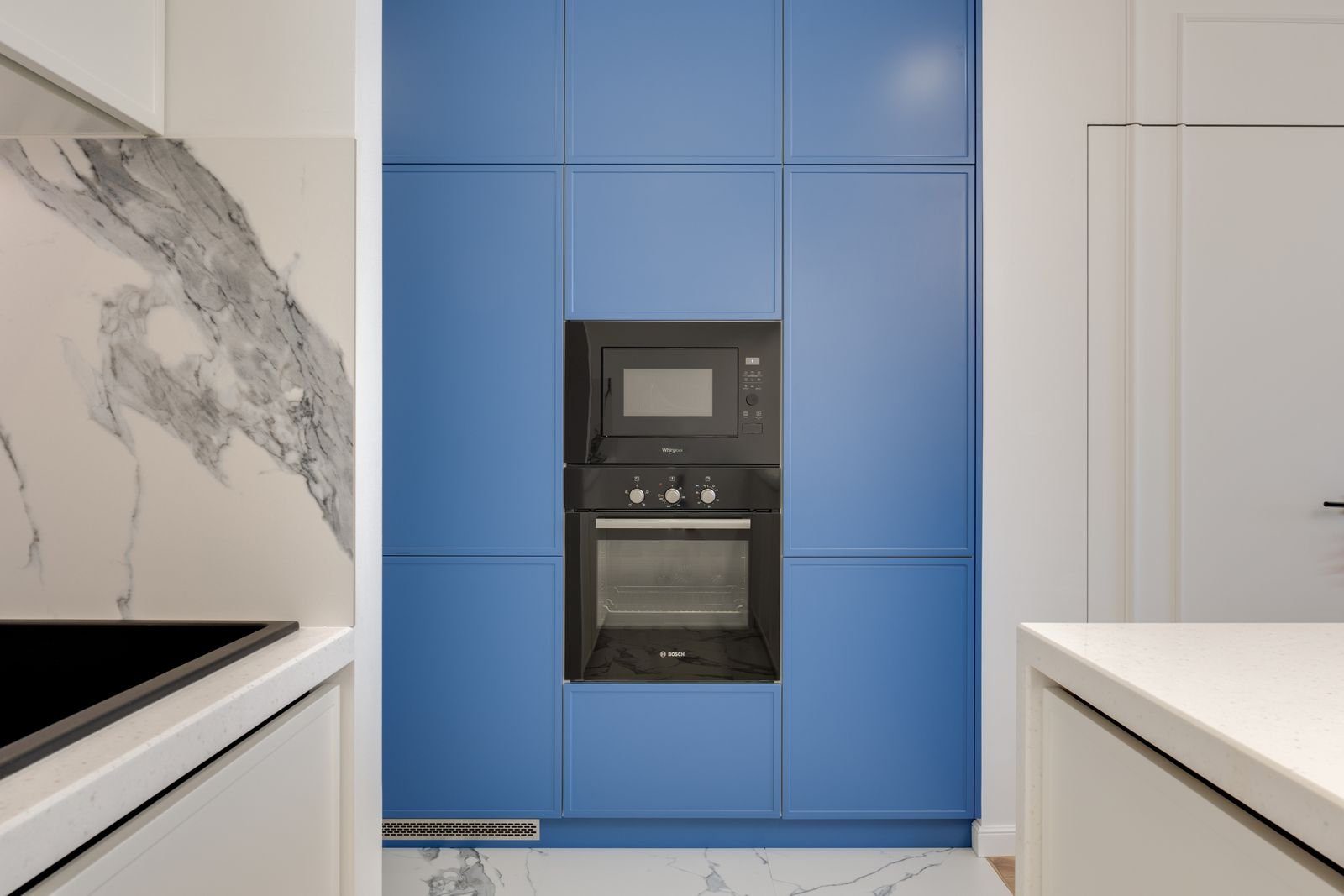 Built in wall oven and microwave set in blue cabinetry